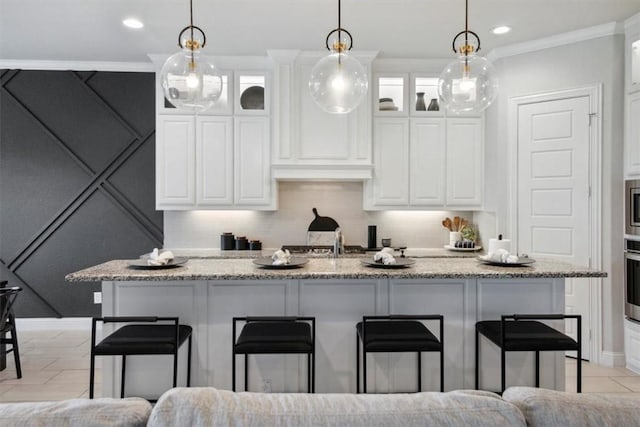 kitchen featuring a kitchen breakfast bar, tasteful backsplash, light stone counters, and crown molding