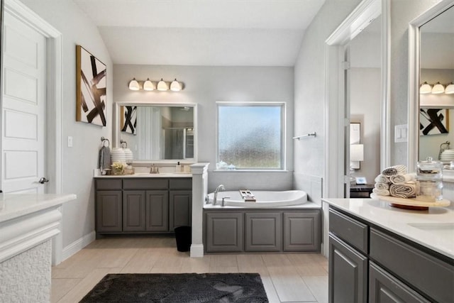 bathroom featuring a bathtub, vanity, and vaulted ceiling