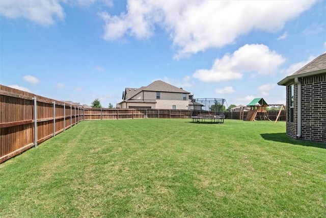 view of yard featuring a trampoline and a playground