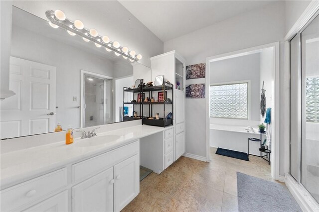 bathroom featuring a stall shower, vanity, and a bath