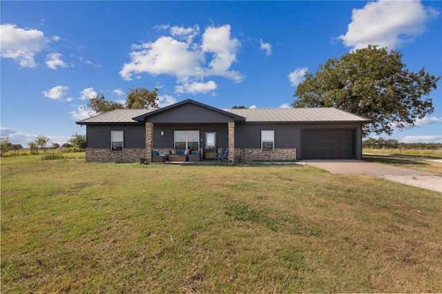 view of front of house featuring a garage, a front yard, concrete driveway, and metal roof