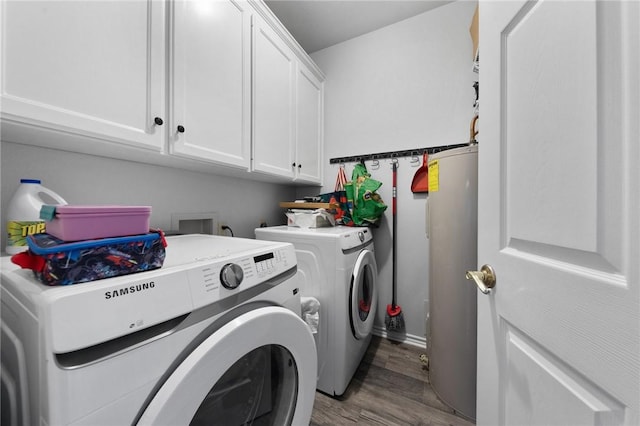 clothes washing area with hardwood / wood-style flooring, washer and dryer, cabinets, and water heater