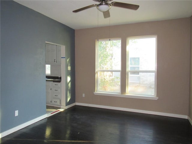 empty room featuring ceiling fan and dark wood-type flooring