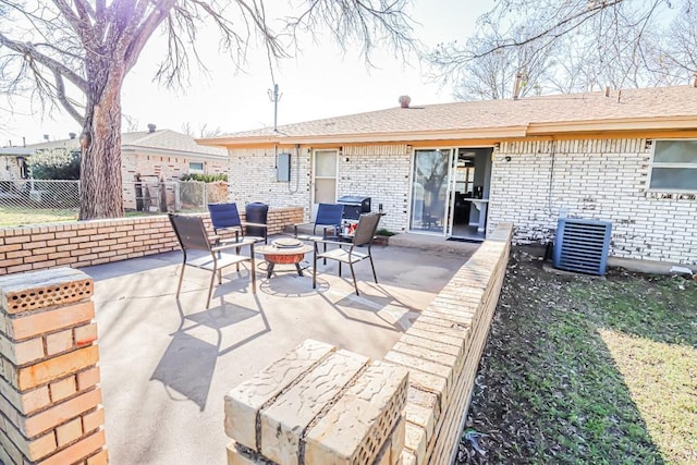 view of patio featuring central air condition unit, an outdoor fire pit, and fence