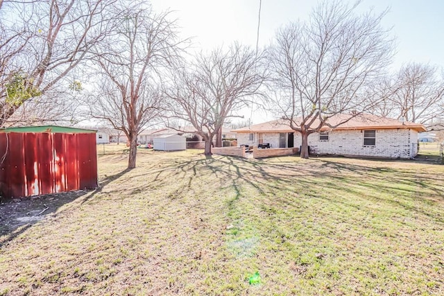 view of yard featuring a storage shed, a deck, and an outdoor structure