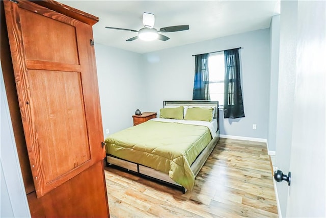 bedroom featuring a ceiling fan, baseboards, and light wood finished floors