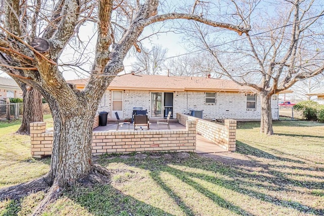 rear view of house featuring central AC unit, fence, a yard, a patio area, and brick siding