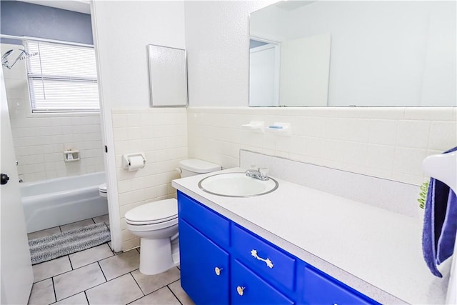 bathroom featuring toilet, a wainscoted wall, tile patterned floors, vanity, and tile walls