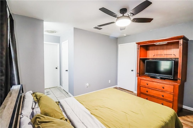 bedroom with a ceiling fan, visible vents, and baseboards