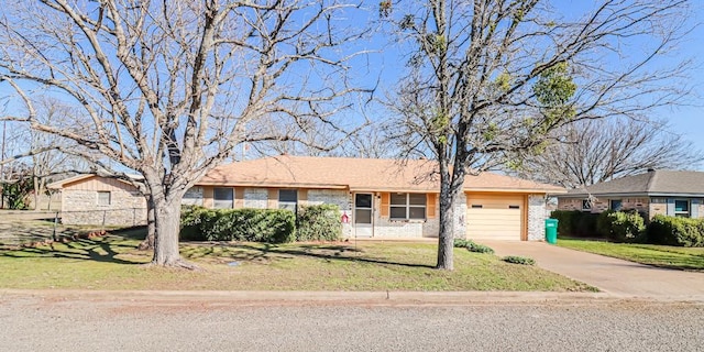 single story home with a garage, a front yard, brick siding, and driveway