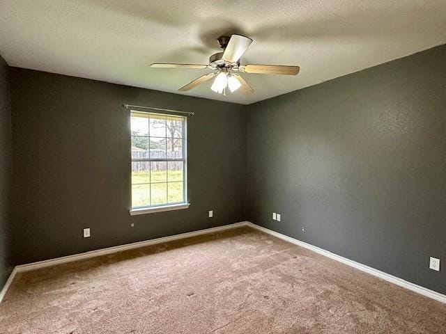 carpeted spare room with a textured ceiling and ceiling fan