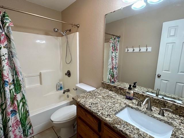 full bathroom with shower / bath combination with curtain, tile patterned floors, vanity, and toilet