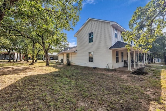 rear view of property featuring a patio and a lawn