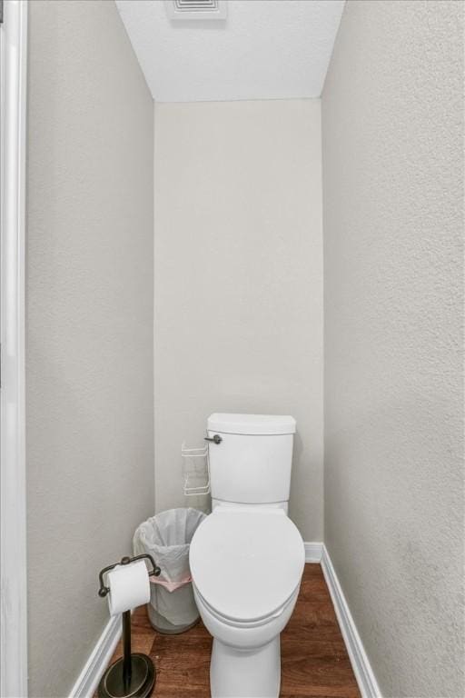 bathroom featuring toilet, baseboards, and wood finished floors