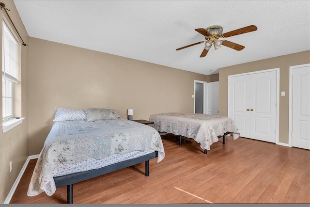 bedroom with baseboards, wood finished floors, and a ceiling fan