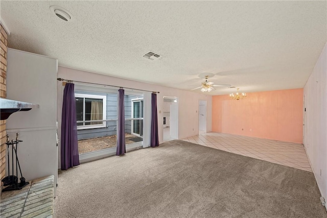 unfurnished living room featuring ceiling fan with notable chandelier, a textured ceiling, and light colored carpet