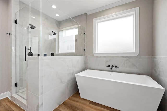 bathroom featuring separate shower and tub, hardwood / wood-style floors, and tile walls