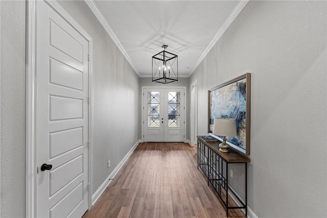 doorway featuring wood-type flooring, an inviting chandelier, french doors, and ornamental molding