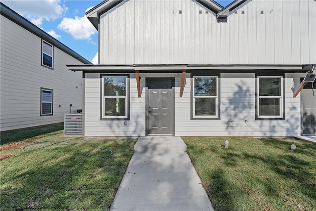 view of front of house with a front lawn and central air condition unit