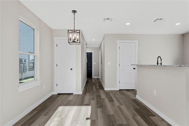 unfurnished dining area with dark hardwood / wood-style floors and a notable chandelier