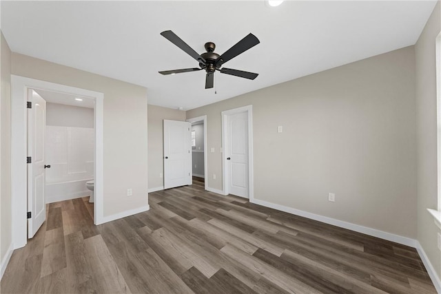 unfurnished bedroom with ceiling fan, a closet, wood-type flooring, and ensuite bath