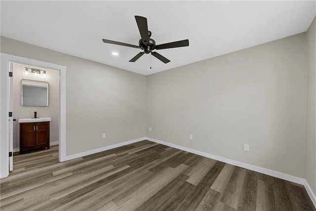 unfurnished bedroom with connected bathroom, ceiling fan, and wood-type flooring