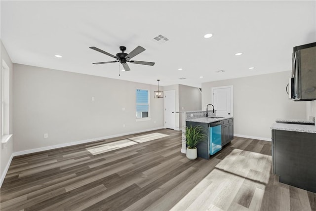 kitchen with a kitchen island with sink, dark wood-type flooring, ceiling fan, and hanging light fixtures