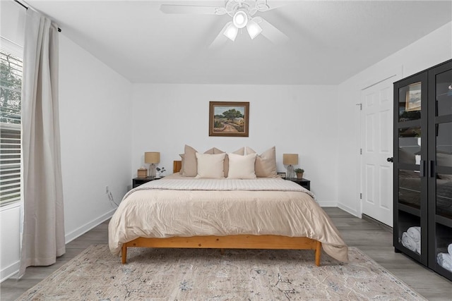 bedroom with wood finished floors, baseboards, and ceiling fan