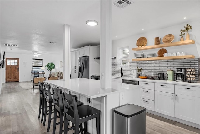 kitchen featuring visible vents, tasteful backsplash, appliances with stainless steel finishes, and a center island