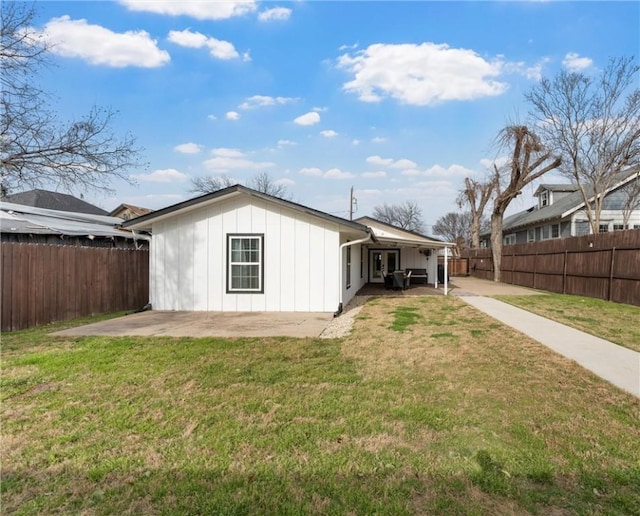 rear view of house featuring a yard, a patio, and a fenced backyard