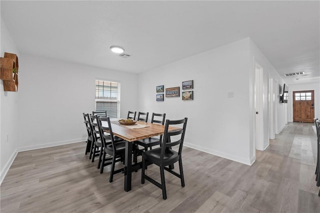 dining space with visible vents, baseboards, and light wood-style floors