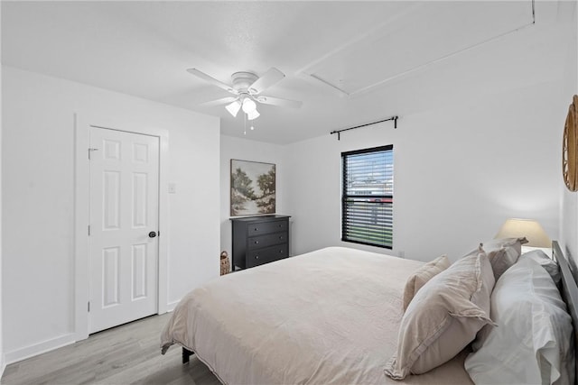 bedroom featuring a ceiling fan, wood finished floors, and baseboards