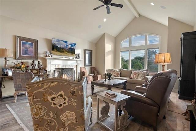 living room featuring beamed ceiling, hardwood / wood-style flooring, high vaulted ceiling, and ceiling fan