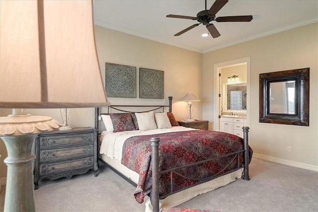 carpeted bedroom featuring ensuite bath, ceiling fan, crown molding, and sink