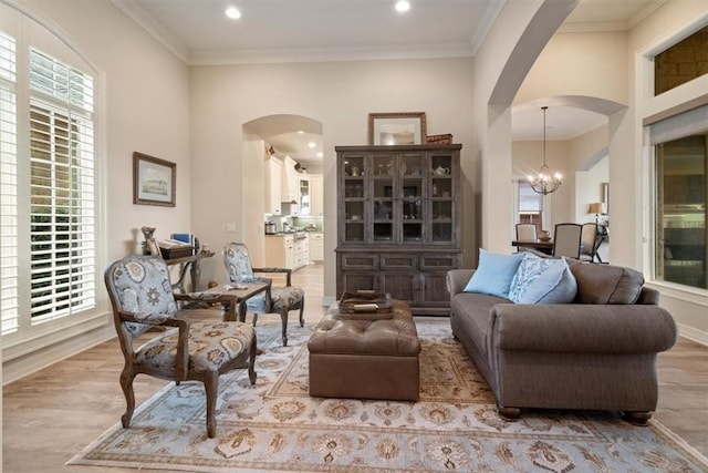 sitting room featuring crown molding, light hardwood / wood-style floors, and an inviting chandelier