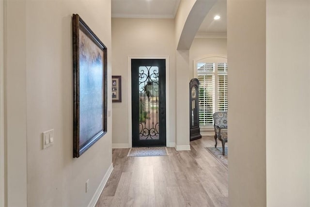 foyer with light hardwood / wood-style floors and ornamental molding