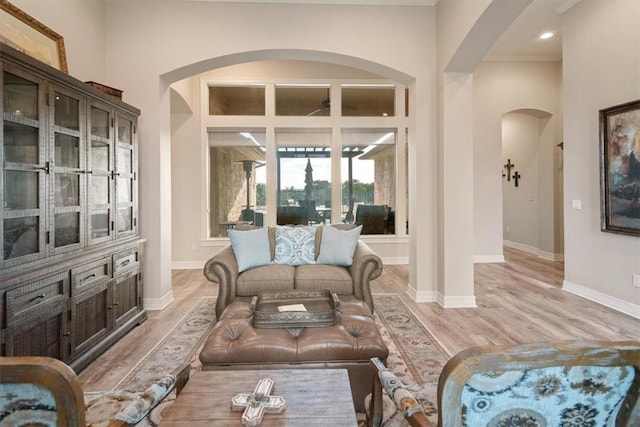 living room featuring light wood-type flooring and crown molding