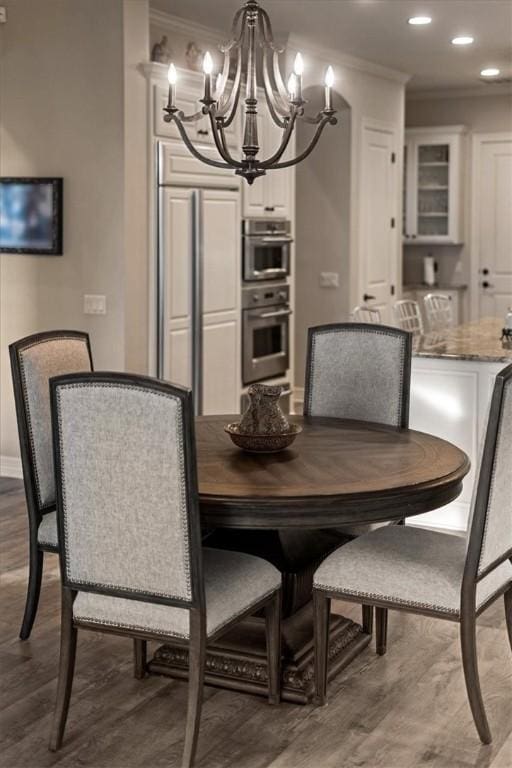 dining space with a notable chandelier, dark hardwood / wood-style floors, and ornamental molding