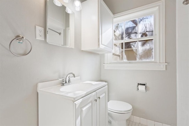 bathroom with toilet, vanity, and tile patterned floors