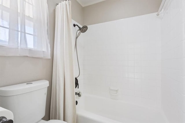 bathroom featuring shower / bath combination with curtain and toilet