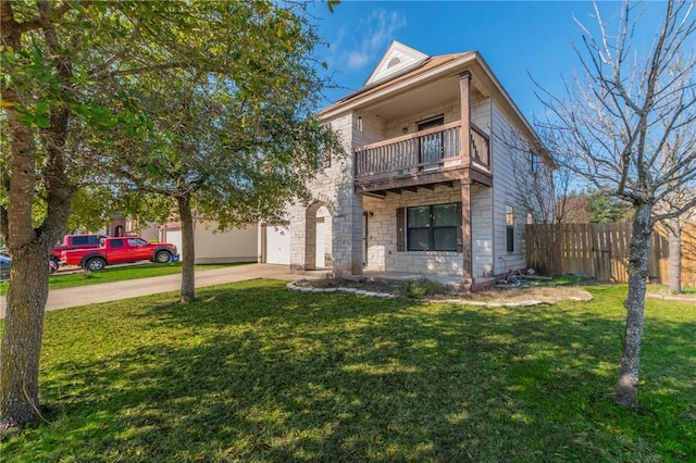 view of front of property featuring a balcony and a front yard