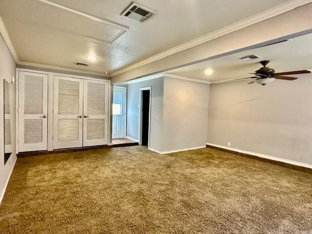 spare room featuring dark colored carpet, ceiling fan, and crown molding