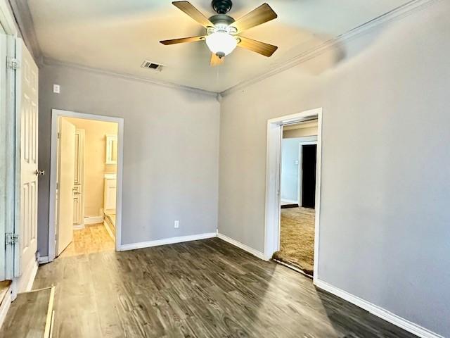 empty room with ceiling fan, dark hardwood / wood-style floors, and ornamental molding