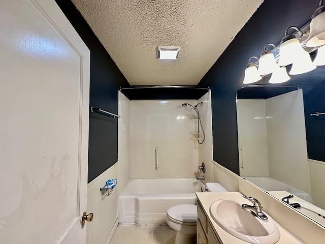 full bathroom featuring vanity, a textured ceiling, washtub / shower combination, tile patterned flooring, and toilet