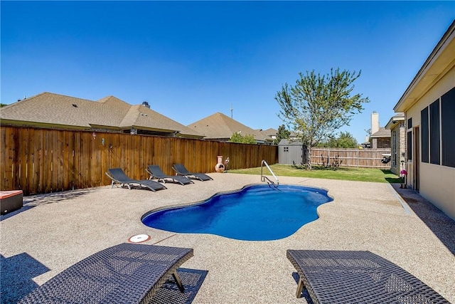 view of swimming pool featuring a patio area and a shed