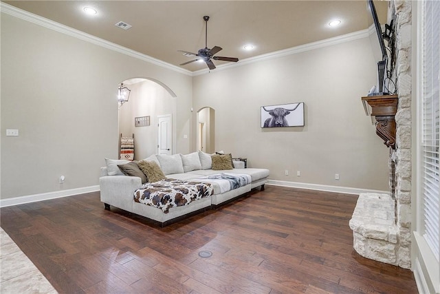 living room featuring a fireplace, dark hardwood / wood-style flooring, ceiling fan, and ornamental molding