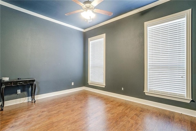 empty room with light hardwood / wood-style floors, a wealth of natural light, and ornamental molding