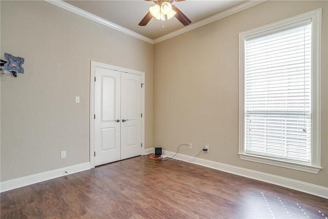 unfurnished room with dark hardwood / wood-style floors, a wealth of natural light, crown molding, and ceiling fan