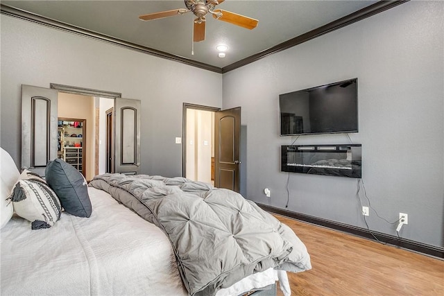 bedroom featuring hardwood / wood-style floors, ceiling fan, and ornamental molding