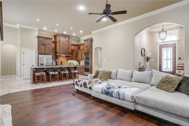 living room with ceiling fan, dark hardwood / wood-style flooring, and ornamental molding